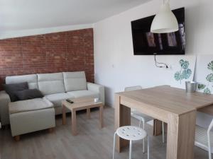 sala de estar con sofá y mesa en San Antonio Suites Vitoria, en Vitoria-Gasteiz