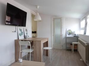 a living room with a table and a tv on a wall at San Antonio Suites Vitoria in Vitoria-Gasteiz