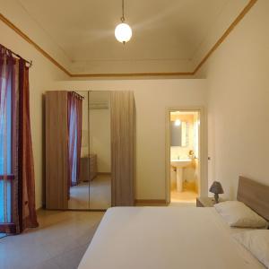 - une chambre avec un lit et une salle de bains avec un miroir dans l'établissement Appartamento Corso Savoia, à Rosolini