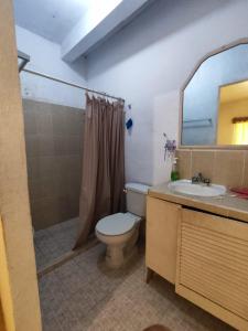y baño con aseo, lavabo y espejo. en Casa Giron en Cancún