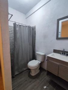 y baño con aseo y lavamanos. en Casa Giron en Cancún