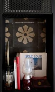 ein Bücherregal mit einer Lampe, Büchern und einer Schachtel in der Unterkunft Casa 3D'Oro Palermo in Palermo