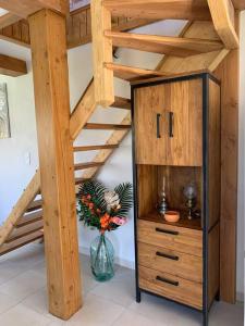 a vase with flowers in a room with stairs at Chez Camille aux Sieges in Les Rives