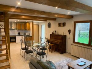 a living room with a table and a piano at Chez Camille aux Sieges in Les Rives