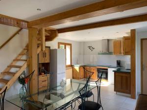 a kitchen with a glass table and a refrigerator at Chez Camille aux Sieges in Les Rives