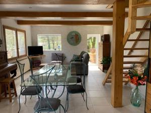 a living room with a glass table and chairs at Chez Camille aux Sieges in Les Rives +48 photos