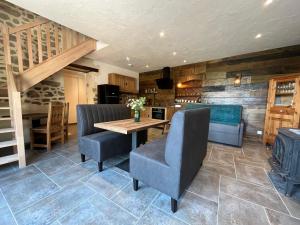 - une salle à manger avec une table et des chaises en bois dans l'établissement Maison d'hôte avec sauna et jacuzzi à la campagne, à Les Portes du Coglais