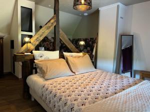 - une chambre avec un grand lit dans l'établissement Maison d'hôte avec sauna et jacuzzi à la campagne, à Les Portes du Coglais