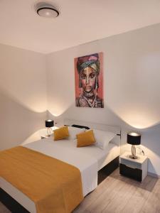 a bedroom with a bed with a painting on the wall at Feel Good View in Trogir