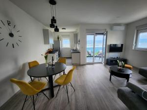 a living room with a table and yellow chairs at Feel Good View in Trogir