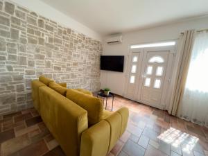 - un salon avec un canapé et un mur en briques dans l'établissement Apartments Melita, à Podstrana