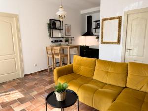 - un salon avec un canapé jaune et une table dans l'établissement Apartments Melita, à Podstrana