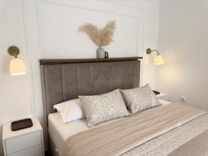 - un lit avec deux oreillers et une tête de lit dans une chambre dans l'établissement Apartments Melita, à Podstrana