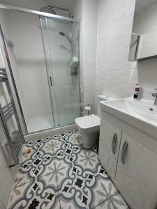 a bathroom with a shower and a toilet and a sink at Premium flat! Enjoy luxurious white Egyptian bedding near Gants Hill Station, Ilford, London in Wanstead