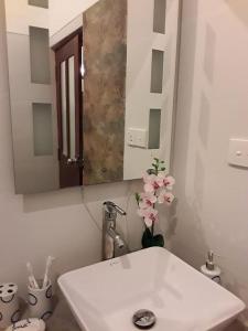 a bathroom with a white sink and a mirror at Aqua Marine Beach Hotel in Kalkudah