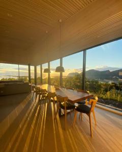 a dining room with a table and chairs and windows at Senjavista, near nature, sea and mighty mountains in Skaland