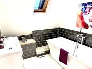 a bathroom with a sink and a bath tub at The Lodge Annex - immaculate coastal property in Oystermouth