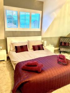 a bedroom with a large bed with red pillows at The Lodge Annex - immaculate coastal property in Oystermouth