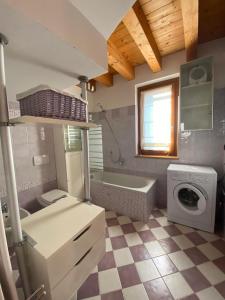 a bathroom with a sink and a washing machine at Red Chair House in Riva di Solto