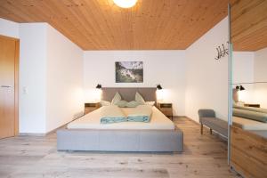 - une chambre avec un lit et un plafond en bois dans l'établissement Haus Binder, à Neustift im Stubaital