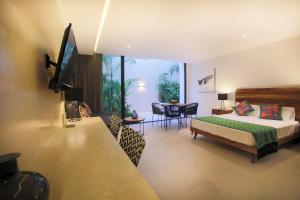 a hotel room with a bed and a television at RIVA Playa Sur in Playa del Carmen