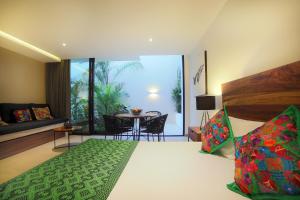 a bedroom with a bed and a table with chairs at RIVA Playa Sur in Playa del Carmen