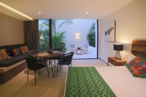 sypialnia z łóżkiem, stołem i kanapą w obiekcie RIVA Playa Sur w mieście Playa del Carmen