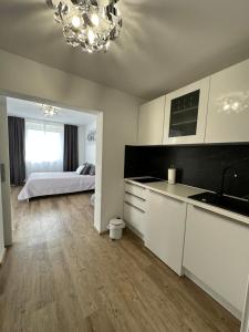 eine Küche mit weißen Schränken und ein Bett in einem Zimmer in der Unterkunft Apartmaji Meli Pu 2 in Izola