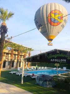 a hot air balloon flying over a swimming pool at Pamukkale Apollon Garden in Denizli