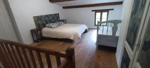 a bedroom with a bed and a wooden floor at Cabanon L'Olivier in Valensole