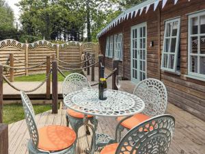 una mesa y sillas en una terraza con una botella de vino en The Haven Lodge, en Clifton