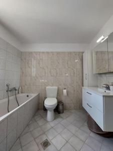 een badkamer met een toilet, een bad en een wastafel bij Giannata House in Kefallonia