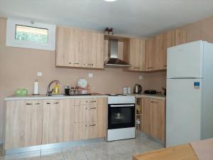 a kitchen with wooden cabinets and a white refrigerator at Giannata House in Argostoli