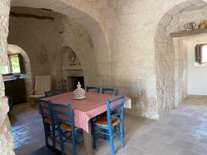 a table with chairs and a vase on top of it at Trullo Raimondo in Martina Franca