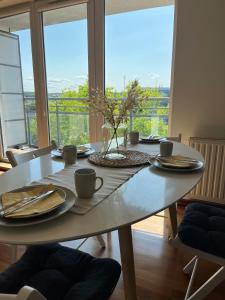 a dining room table with plates and cups on it at Prime Home SŁONECZNY in Gdynia