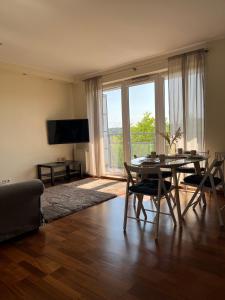 a living room with a table and chairs and a large window at Prime Home SŁONECZNY in Gdynia