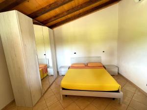 a bedroom with a yellow bed in a room at Agriturismo Paradiso in Castiglione della Pescaia
