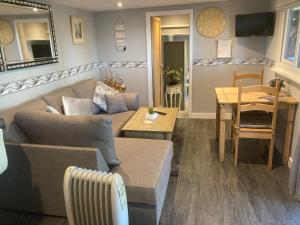 a living room with a couch and a table at The Spinney lodge in Bubbenhall