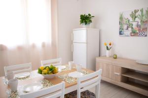 ein Esszimmer mit einem Tisch und einem weißen Kühlschrank in der Unterkunft Donna Agata House in Catania