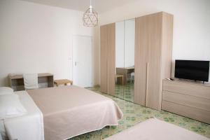 ein Hotelzimmer mit einem Bett und einem Flachbild-TV in der Unterkunft Donna Agata House in Catania