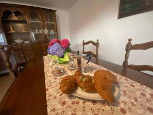 un tavolo con un piatto di croissant e fiori di Casa vacanze il pettirosso. a Pisogne
