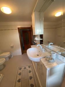 a bathroom with a sink and a toilet at Casa vacanze il pettirosso. in Pisogne