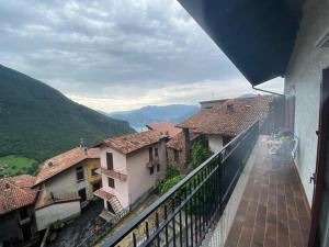 balcone con vista su alcuni edifici e sulle montagne. di Casa vacanze il pettirosso. a Pisogne
