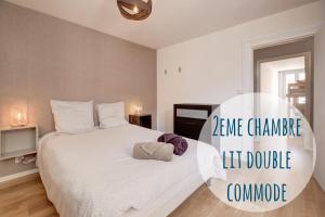 a bedroom with a large white bed in a room at « Le Bidule », logement au cœur de la Champagne in Chouilly