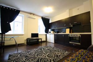 a kitchen with black cabinets and a rug on the floor at Main Street Apartments in Chişinău