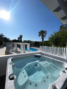 bañera de hidromasaje en un patio junto a la piscina en Zoumis Residence en Náousa