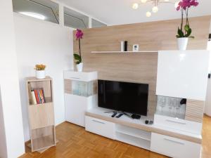 a living room with a tv on a white cabinet at Apartment Mateo in Maribor