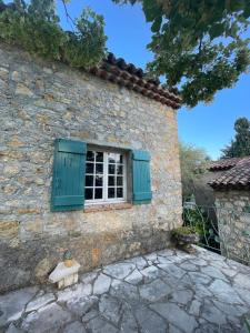 蒙托魯的住宿－Clos de la Gipiere，石屋的窗户,带绿色百叶窗