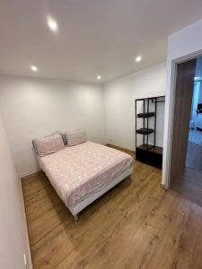 um quarto com uma cama e piso em madeira em Apt Moderne 2 chambres 5 voyageurs Paris em Paris