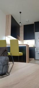 a room with two yellow chairs and a kitchen at Apartman Stevanovic BN in Bijeljina